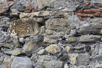 Image showing Very old wall from stones of various shapes and red bricks