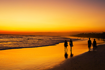 Image showing People walking ocean beach sunset