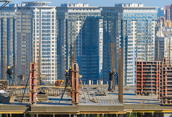 Image showing Construction workers work top building