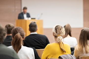 Image showing Speaker giving a talk in conference hall at business event. Rear view of unrecognizable people in audience at the conference hall. Business and entrepreneurship concept.