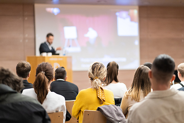 Image showing Speaker giving a talk in conference hall at business event. Rear view of unrecognizable people in audience at the conference hall. Business and entrepreneurship concept.