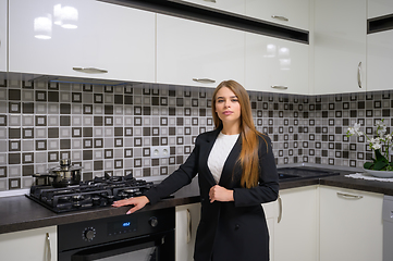 Image showing Young woman at luxury modern black and white kitchen interior in provence style