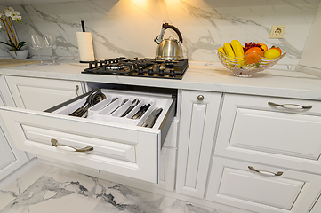 Image showing Open drawer with cutlery at modern white woden kitchen in classic style