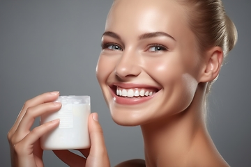 Image showing Smiling Young Woman holds cream container