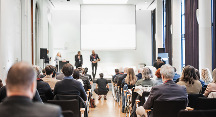 Image showing Business team leader receiving award prize at best business project competition event. Business and entrepreneurship award ceremony theme. Focus on unrecognizable people in audience.