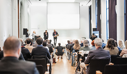 Image showing Business team leader receiving award prize at best business project competition event. Business and entrepreneurship award ceremony theme. Focus on unrecognizable people in audience.