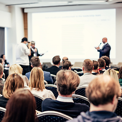 Image showing I have a question. Group of business people sitting in conference hall. Businessman raising his arm. Conference and Presentation. Business and Entrepreneurship