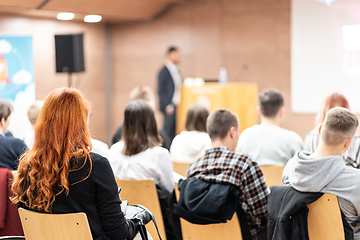 Image showing Speaker giving a talk in conference hall at business event. Rear view of unrecognizable people in audience at the conference hall. Business and entrepreneurship concept.