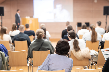 Image showing Speaker giving a talk in conference hall at business event. Rear view of unrecognizable people in audience at the conference hall. Business and entrepreneurship concept.