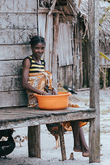 Image showing Malagasy woman washes dishes, Madagascar countryside