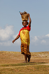 Image showing Malagasy woman carry heavy loads on head. Madagascar