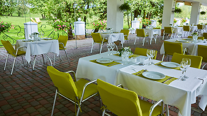 Image showing terrace summer cafe with tables and chairs for people, an empty institution for recreation, nobody