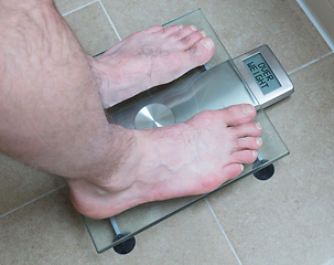 Image showing Man\'s feet on weight scale - Overweight