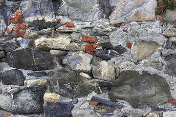 Image showing Vintage wall from stones of various shapes and red bricks