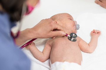 Image showing Baby lying on his back as his doctor examines him during a standard medical checkup