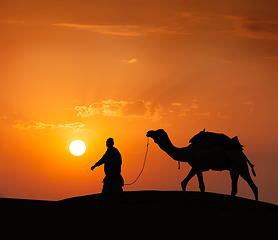 Image showing Cameleer (camel driver) with camels in dunes of Thar desert. Raj