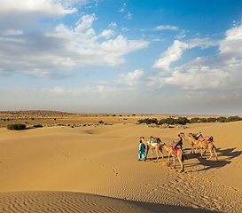 Image showing Two cameleers (camel drivers) with camels in dunes of Thar deser