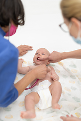 Image showing Baby lying on his back as his doctor examines him during a standard medical checkup