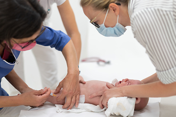 Image showing Baby beeing vaccinated by pediatrician in presence of his mother. Preventive vaccination against Diphtheria, whooping cough, tetanus, hepatitis, haemophilus influenzae, pneumococcus, poliomyelitis