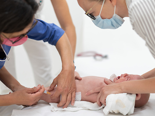 Image showing Baby beeing vaccinated by pediatrician in presence of his mother. Preventive vaccination against Diphtheria, whooping cough, tetanus, hepatitis, haemophilus influenzae, pneumococcus, poliomyelitis