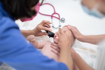 Image showing Baby lying on his back as his doctor examines him during a standard medical checkup