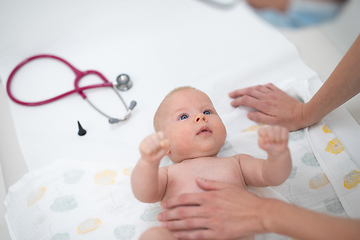 Image showing Baby lying on his back as his doctor examines him during a standard medical checkup