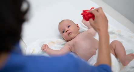 Image showing Baby lying on his back as his doctor examines him during a standard medical checkup