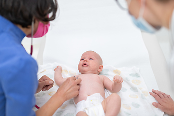 Image showing Baby lying on his back as his doctor examines him during a standard medical checkup