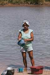 Image showing Malagasy woman washes dishes, Madagascar countryside