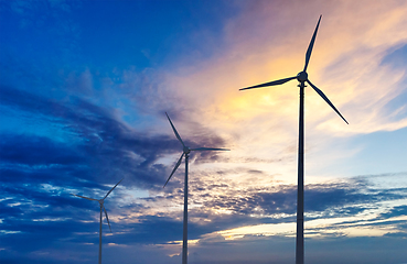 Image showing Wind generator turbines sihouettes on sunset