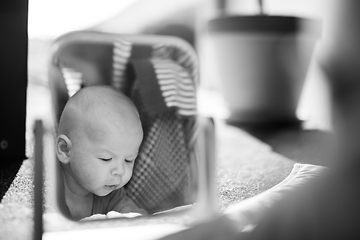 Image showing Beautiful shot of a cute baby boy looking at his reflection in the mirror. Black and white image.