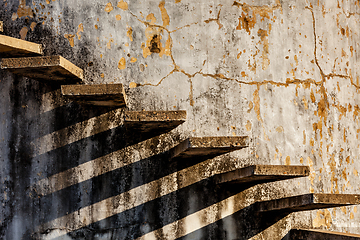 Image showing Stairs casting shadow on old weathered wall