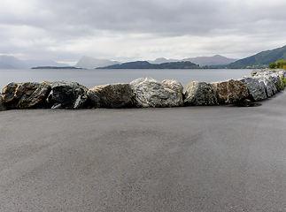 Image showing stone fence on quay with mountains