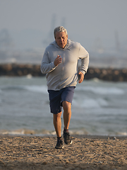 Image showing An elderly man is running