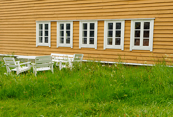 Image showing seating area in field in front of yellow old building