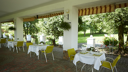 Image showing terrace summer cafe with tables and chairs for people, an empty institution for recreation, nobody