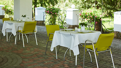 Image showing terrace summer cafe with tables and chairs for people, an empty institution for recreation, nobody