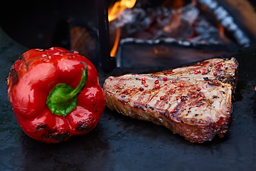 Image showing Grilled T-Bone Steak on serving board on wooden background