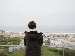 Image showing Teenager in a jacket standing in a balcony