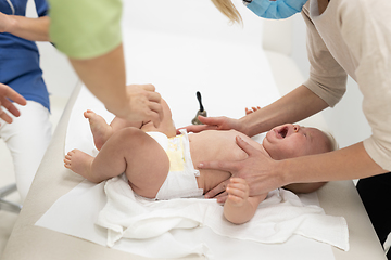 Image showing Baby beeing vaccinated by pediatrician in presence of his mother. Preventive vaccination against Diphtheria, whooping cough, tetanus, hepatitis, haemophilus influenzae, pneumococcus, poliomyelitis