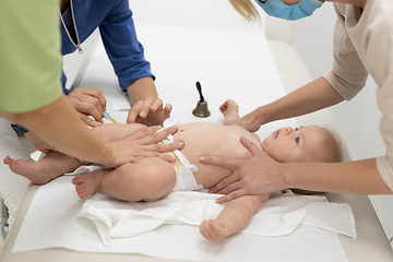 Image showing Baby beeing vaccinated by pediatrician in presence of his mother. Preventive vaccination against Diphtheria, whooping cough, tetanus, hepatitis, haemophilus influenzae, pneumococcus, poliomyelitis