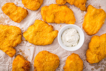 Image showing Small chicken schnitzel on baking sheet with herb mayonnaise 