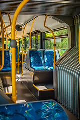 Image showing Interior of a city bus. Empty bus interior. Bus with blue seats and yellow handrails