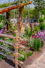 Image showing Detail of natural garden fence made of wooden posts and ropes with native plants and patio