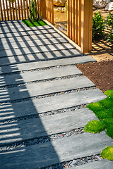 Image showing Detail of slate path with bark mulch and native plants in Japanese garden. Landscaping and gardening concept.