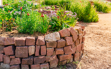 Image showing Herb spiral made of bricks for a small garden with sorrel, garlic mustard and chives