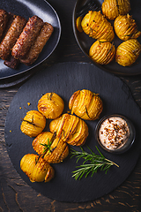 Image showing Hasselback potatoes with additional herbs, spices and whipped feta dip