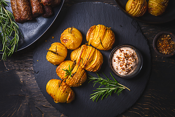 Image showing Hasselback potatoes with additional herbs, spices and whipped feta dip