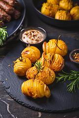 Image showing Hasselback potatoes with additional herbs, spices and whipped feta dip