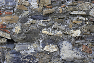 Image showing Vintage wall from stones of various shapes and red bricks